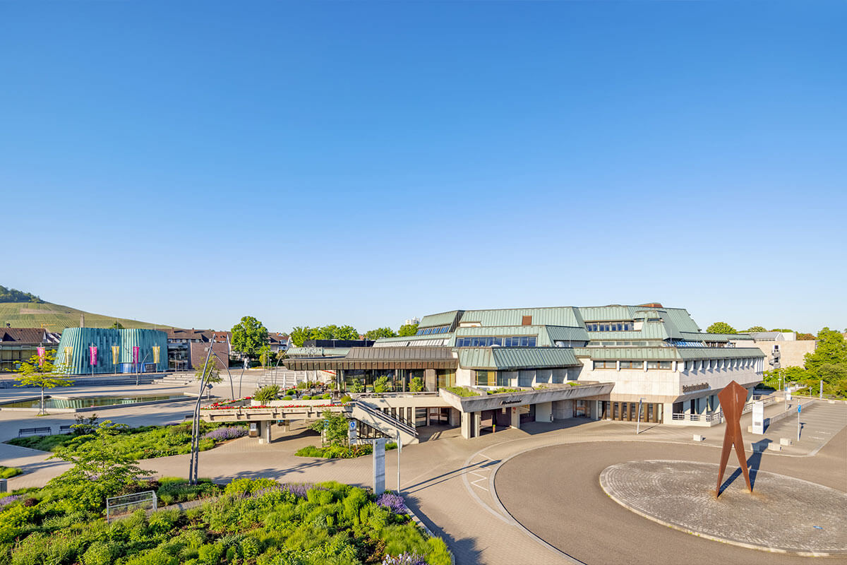 Aussenansicht der Schwabenlandhalle Fellbach bei Tageslicht mit Gartenanlage und Wasserbecken im Vordergrund